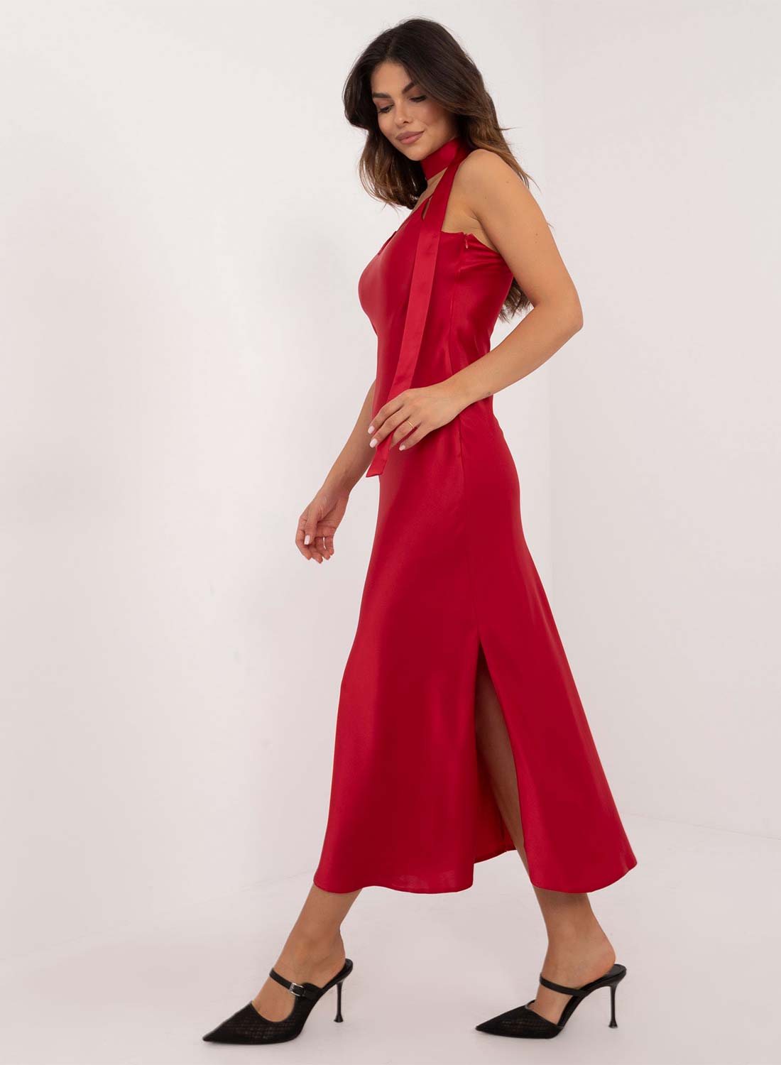 Vestido largo de satén rojo con abertura y cinturón.